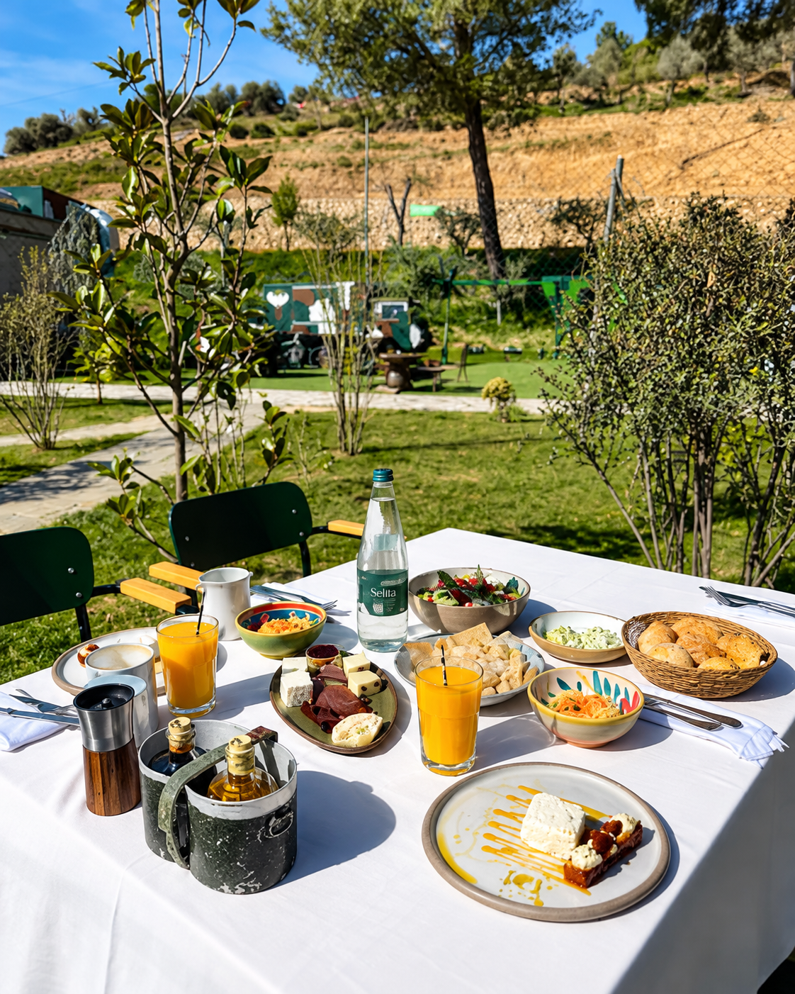 Tavola ricca di piatti tradizionali albanesi nel giardino di Kazerma e Çerenit a Surrel, vicino al Monte Dajti.