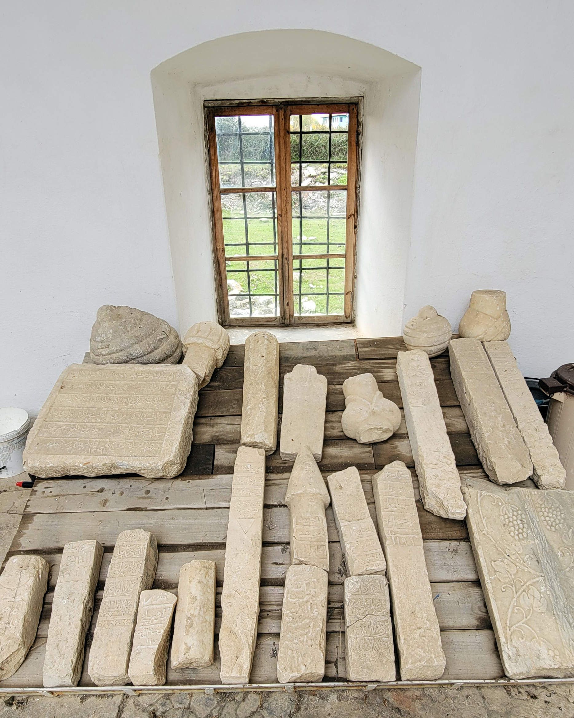 A collection of historic Islamic tombstones with intricate Arabic inscriptions