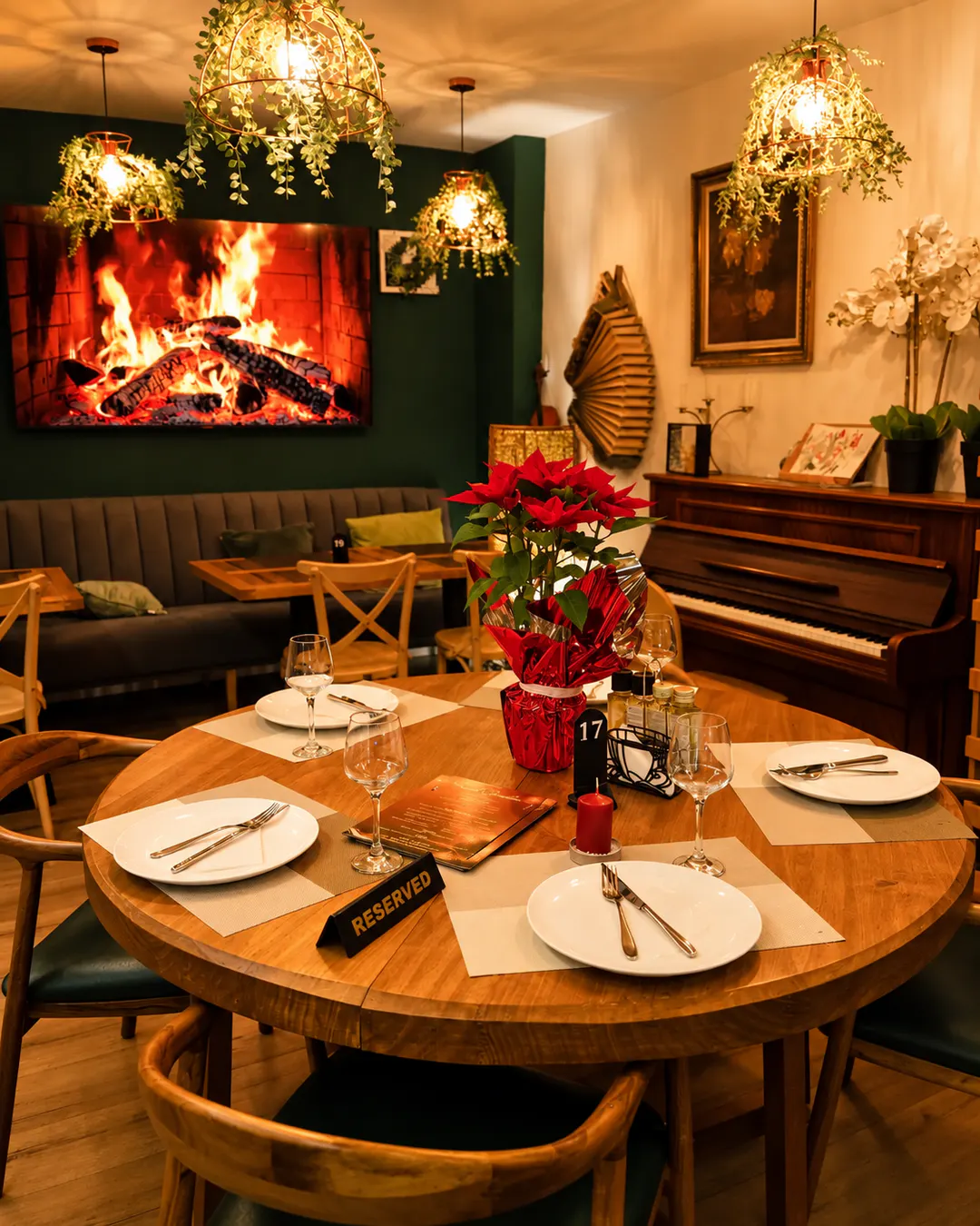Ambient i brendshëm komod i Fresh Garden Restaurant në Bllok, Tiranë, me tavolina druri, mure jeshile, ndriçim të ngrohtë, kitara dekorative dhe zbukurime Krishtlindjesh.
