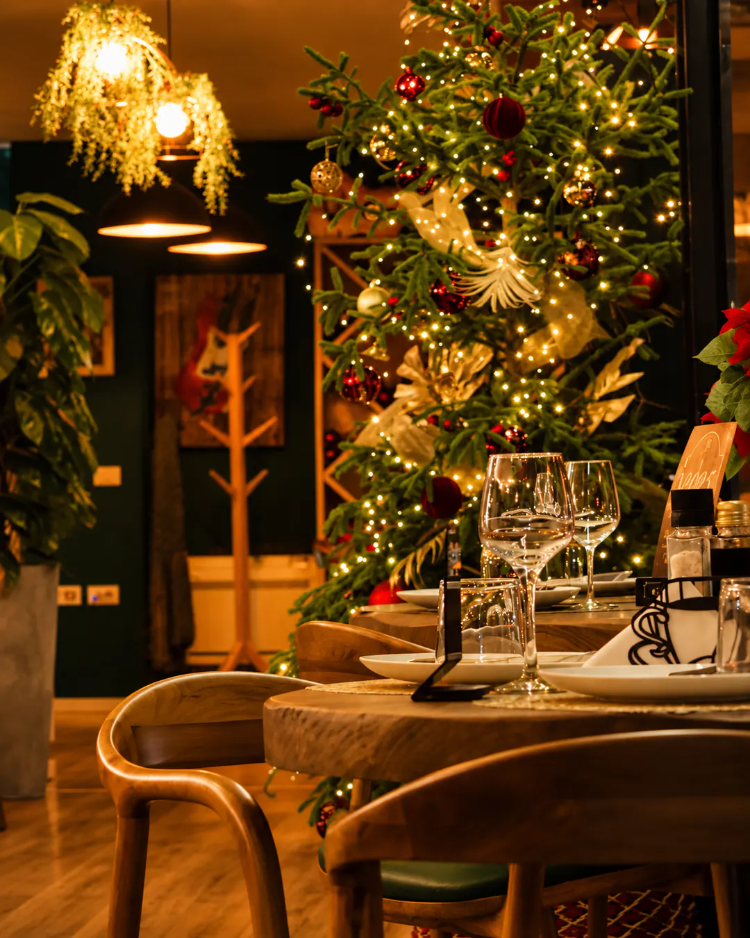 Ambient mikpritës ngrënieje te Fresh Garden Restaurant në Bllok, Tiranë, me tavolinë druri të shtruar bukur, piano, gjelbërim dhe ndriçim të ngrohtë dekorativ.