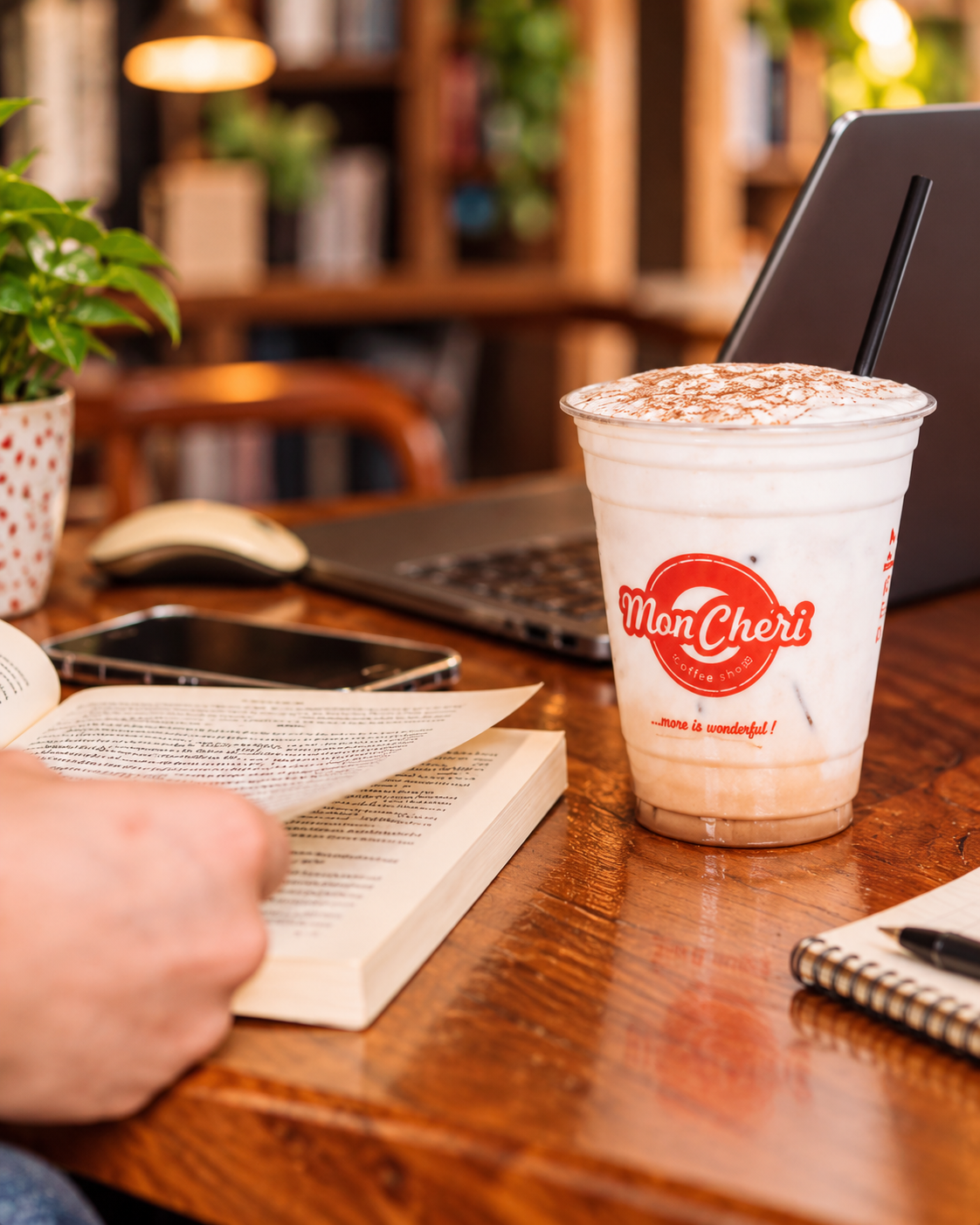 Kafe Mon Cheri e shërbyer pranë një libri të hapur në një kafene të qetë në Tiranë