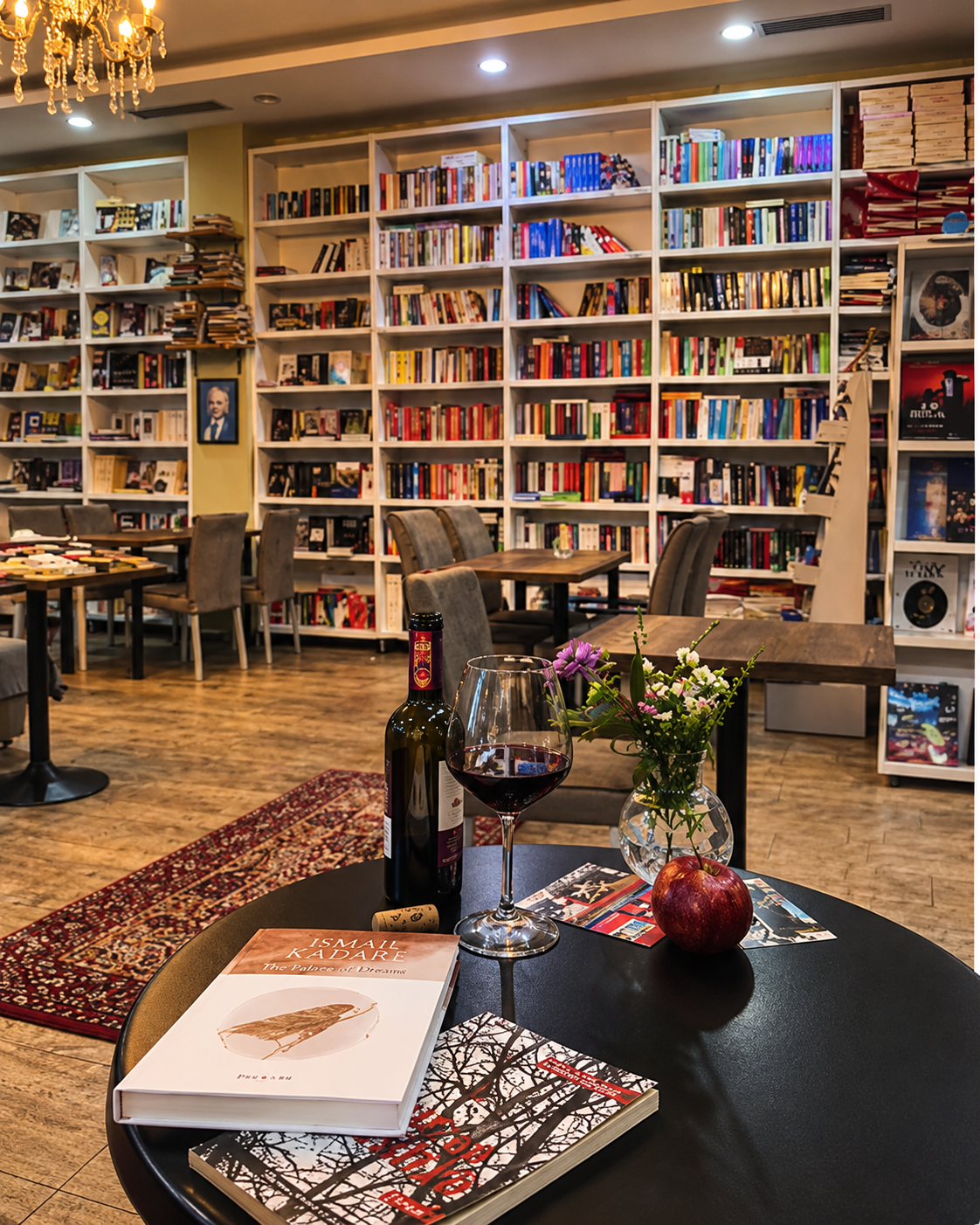 Tirana Times Bookshop & Café me rafte librash, libra dhe verë në Bllok, Tiranë