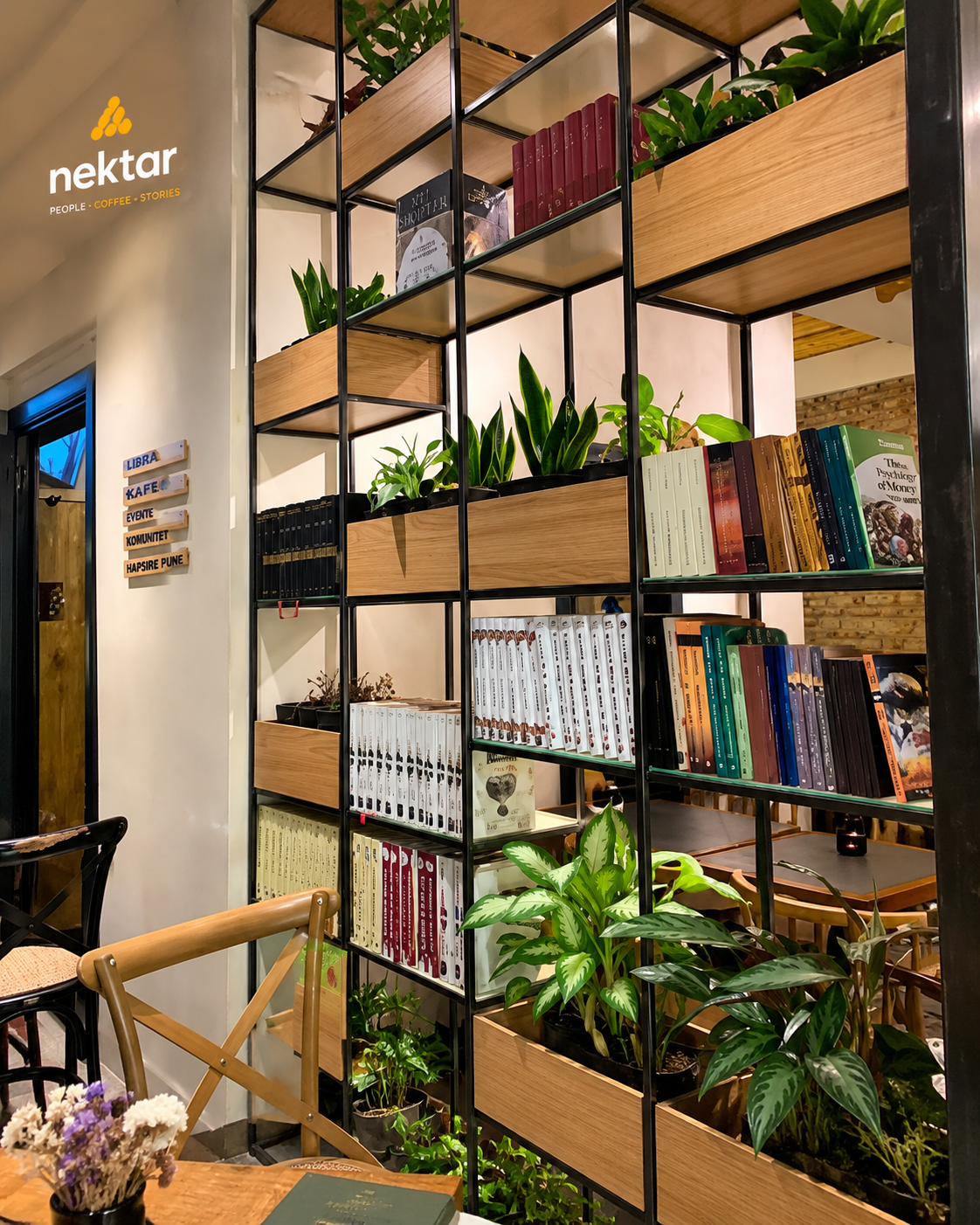 Rafte me libra dhe bimë brenda Nektar Bookcafé në Tiranë