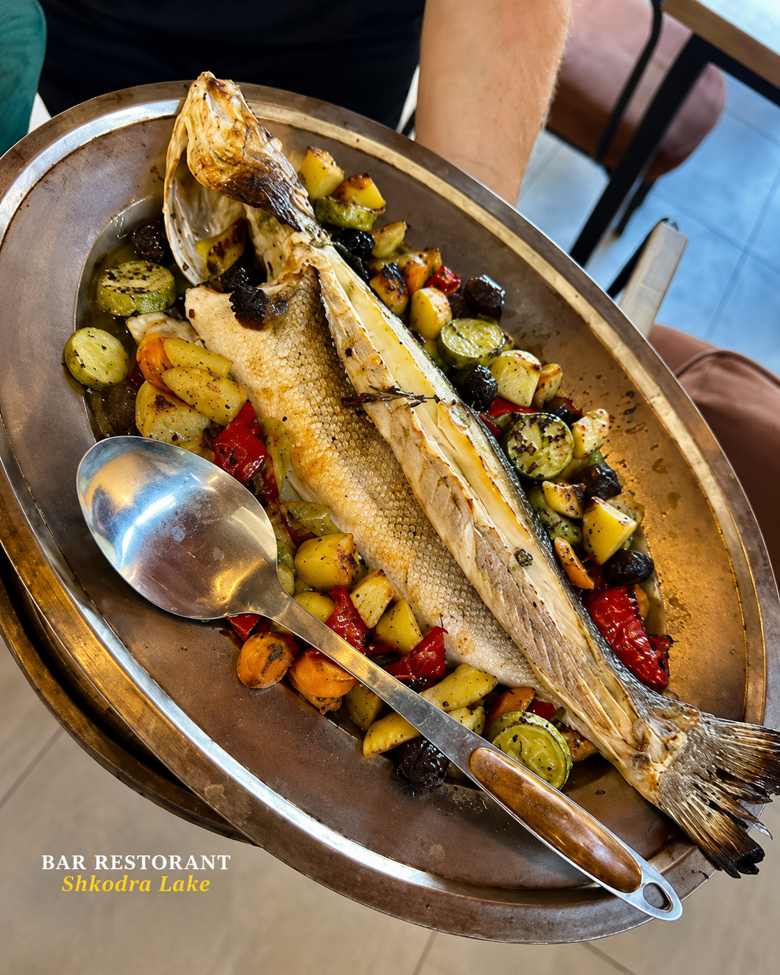 Whole baked fish with vegetables at Shkodra Lake Restaurant