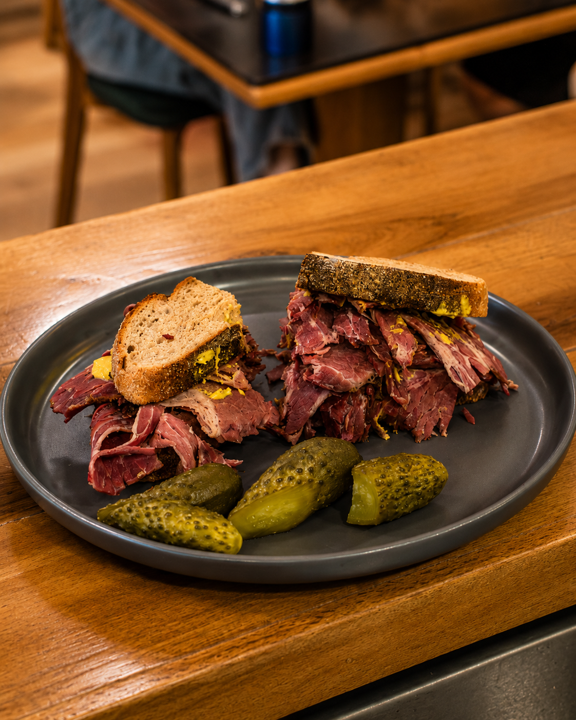 House-made pastrami served with bread and pickles at Delibros