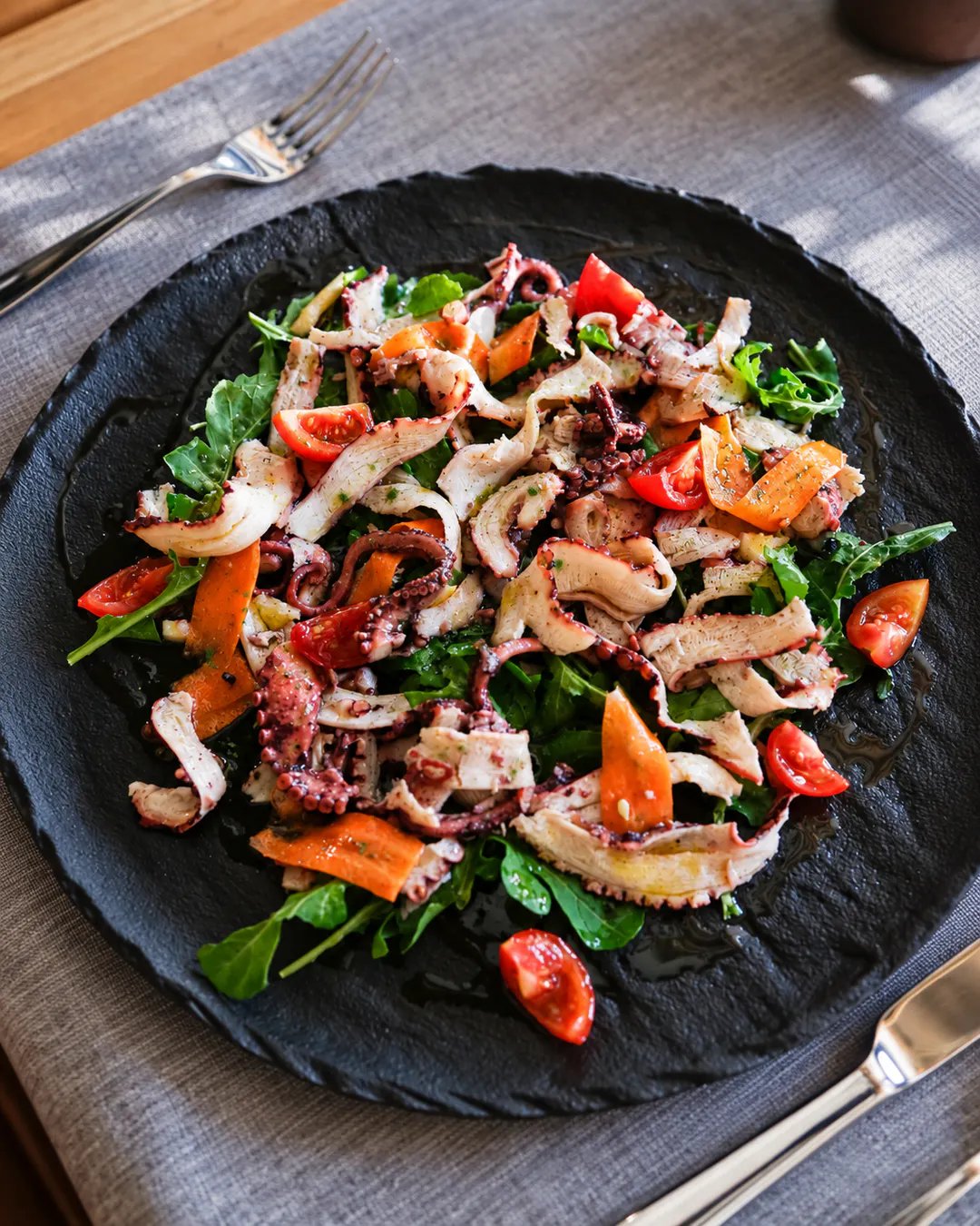 Grilled octopus salad with fresh vegetables at an upscale restaurant in Tirana