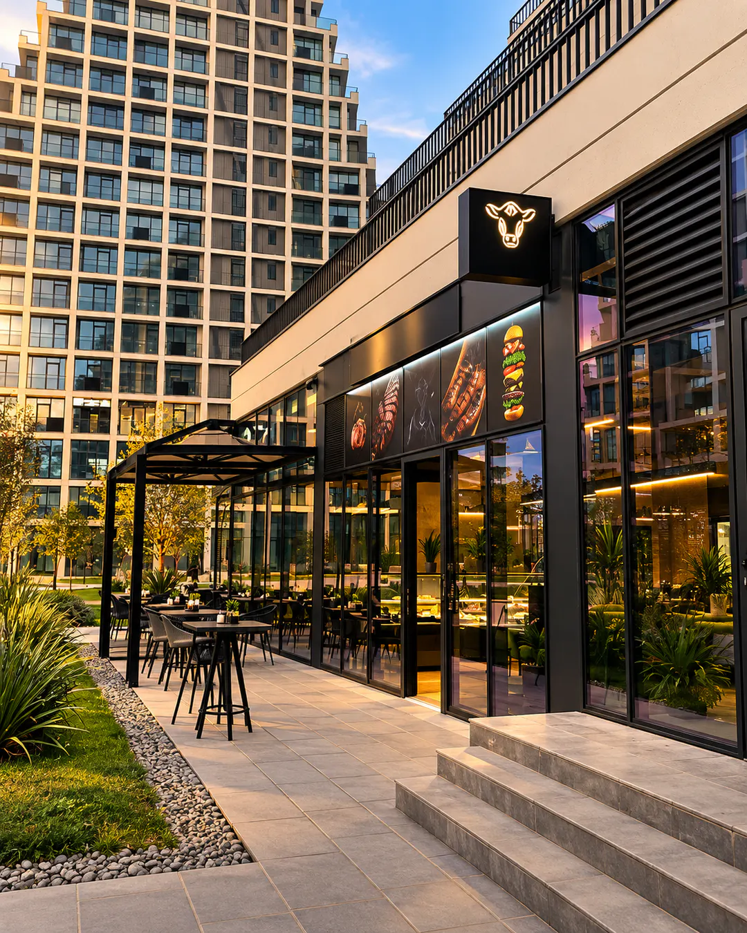 Pamja e jashtme dhe ambienti me tavolina në natyrë i PMG Steakhouse në Tiranë