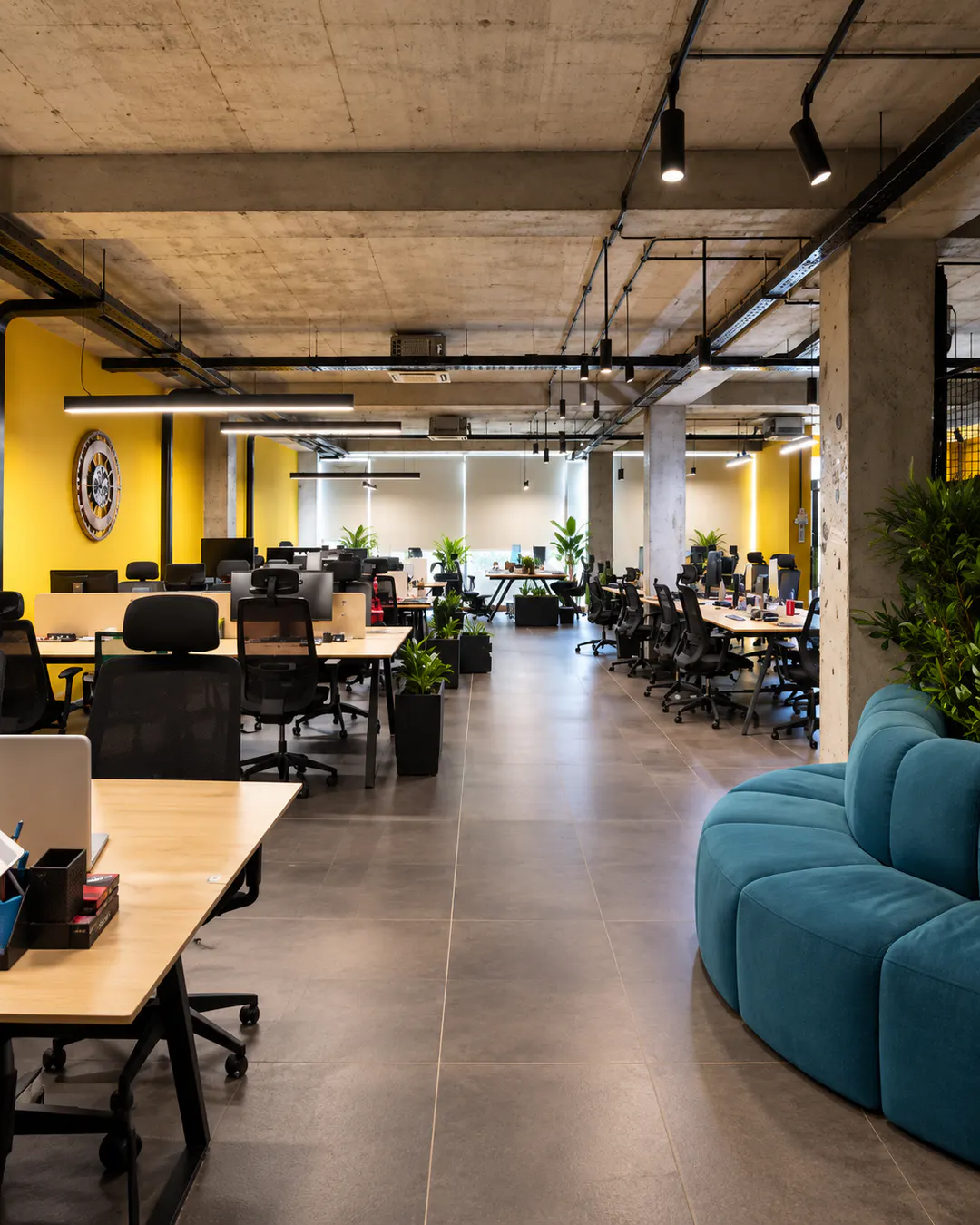 Moderno spazio di coworking open space con scrivanie e area lounge presso Social Hub Tirana