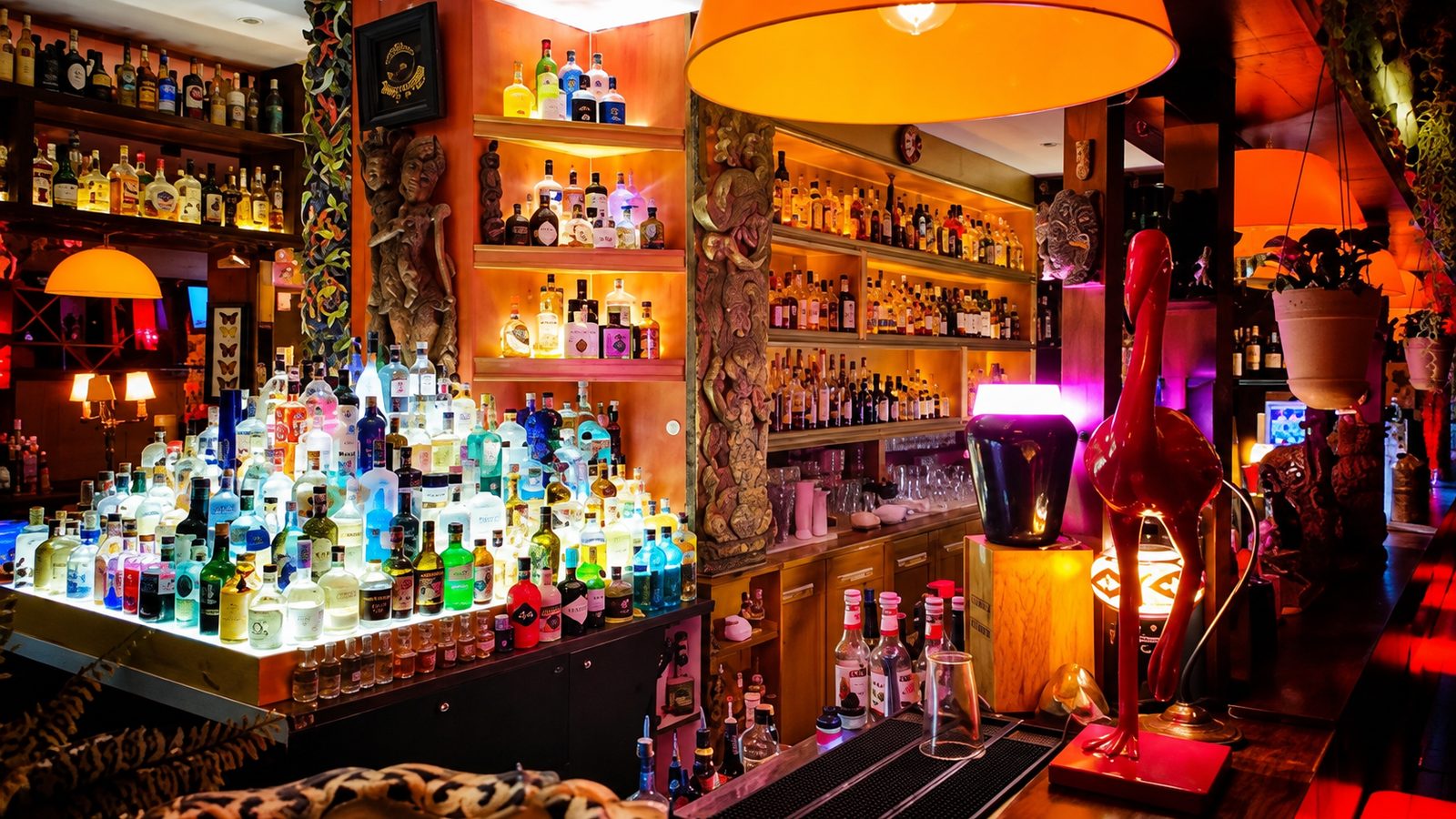 Interior of Colonial Cocktails Academy in Tirana, Albania, featuring an illuminated cocktail bar, colorful bottles and elegant vintage decor.
