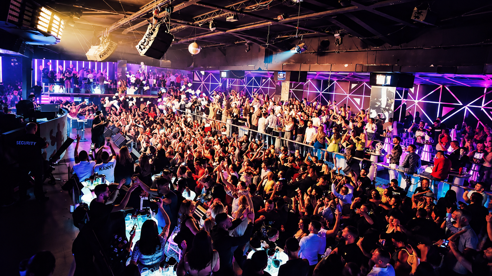 Crowded dance floor at Cinco Cavalli Premium Club in Tirana, Albania, with vibrant purple lighting and energetic nightlife atmosphere.