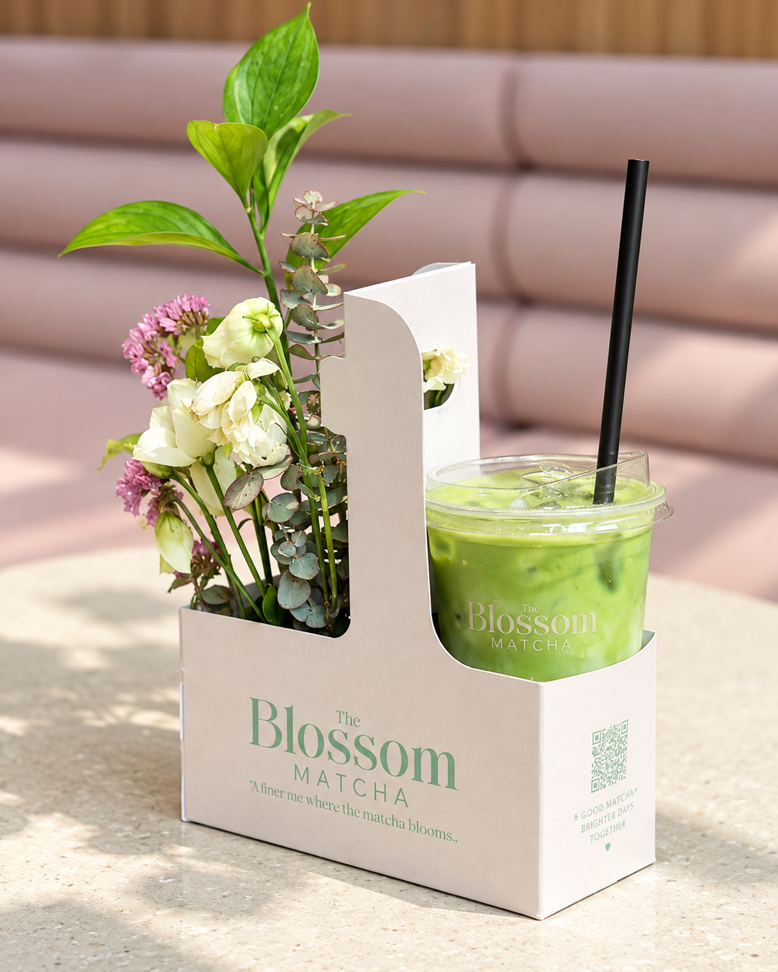 Iced matcha latte with fresh flowers in The Blossom Matcha signature takeaway packaging at the café in Tirana, Albania.