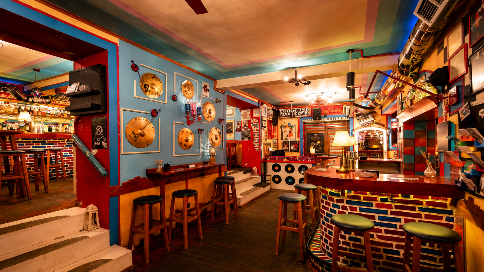 Colorful interior of Nouvelle Vague cocktail bar in Tirana with bar seating and creative decor