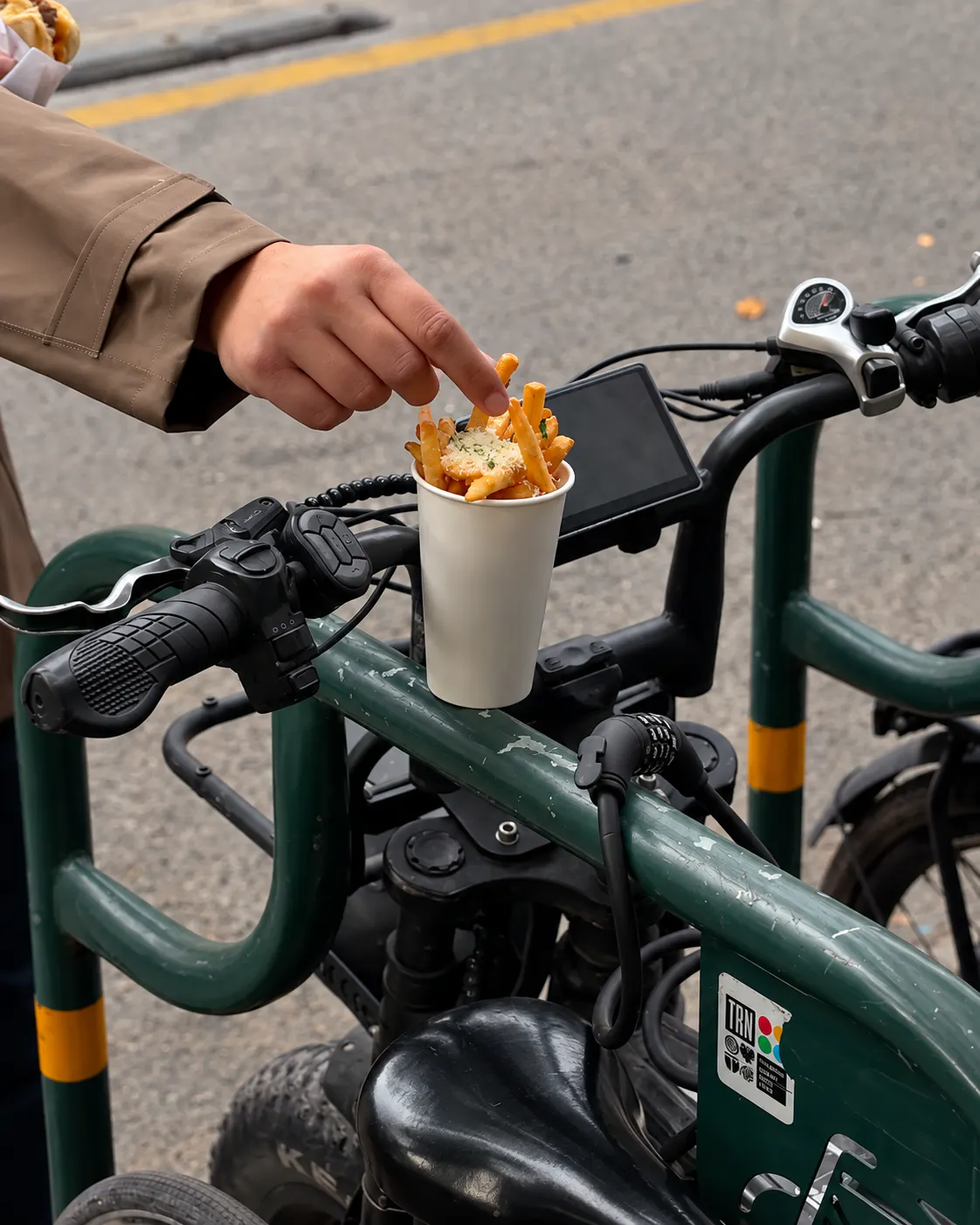 Crispy fries topped with grated cheese served in a takeaway cup at Brio’s in Tirana.