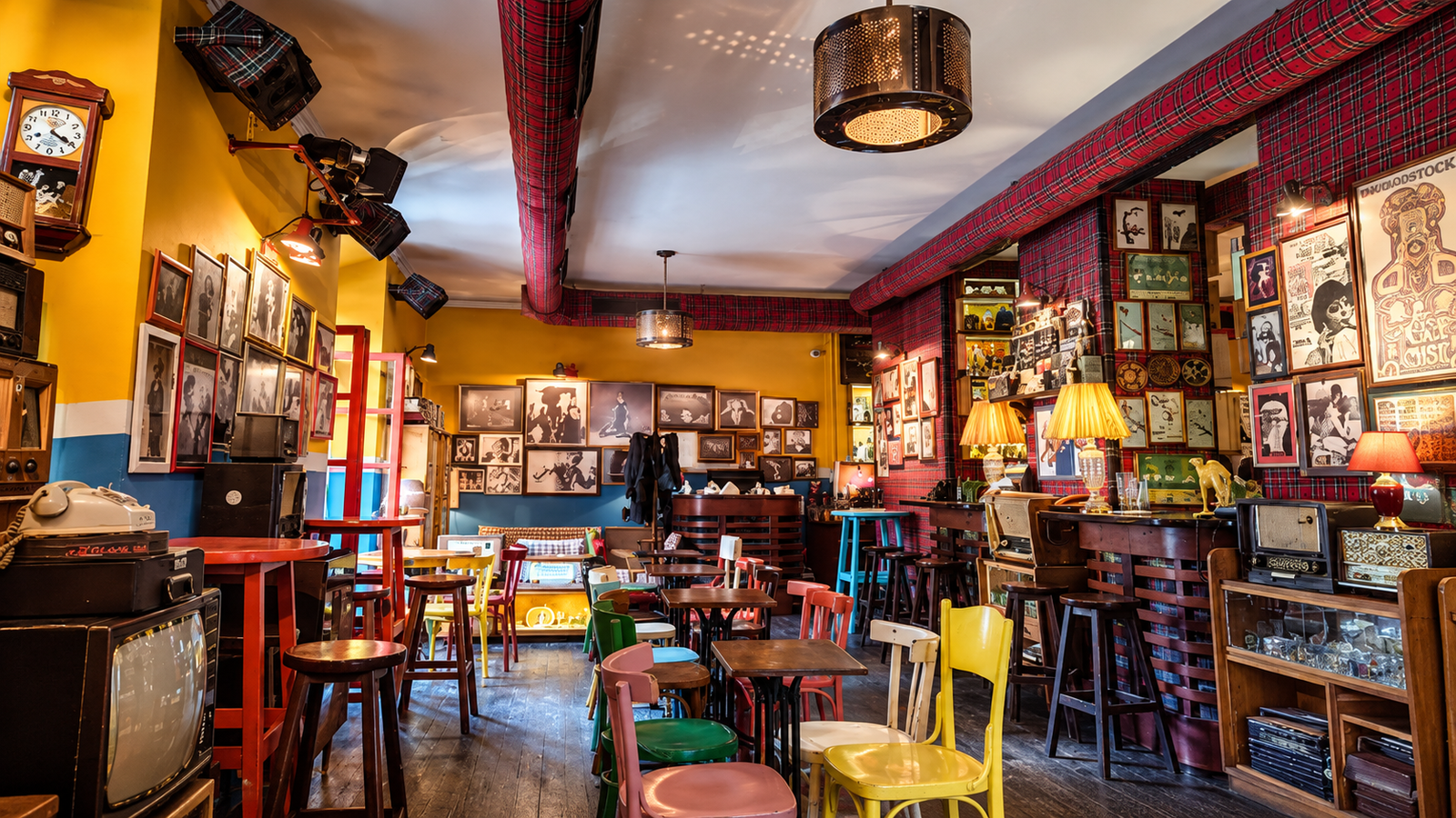 Retro interior of Radio Bar in Tirana, Albania, featuring vintage radios, colorful chairs, nostalgic decor and warm lighting.
