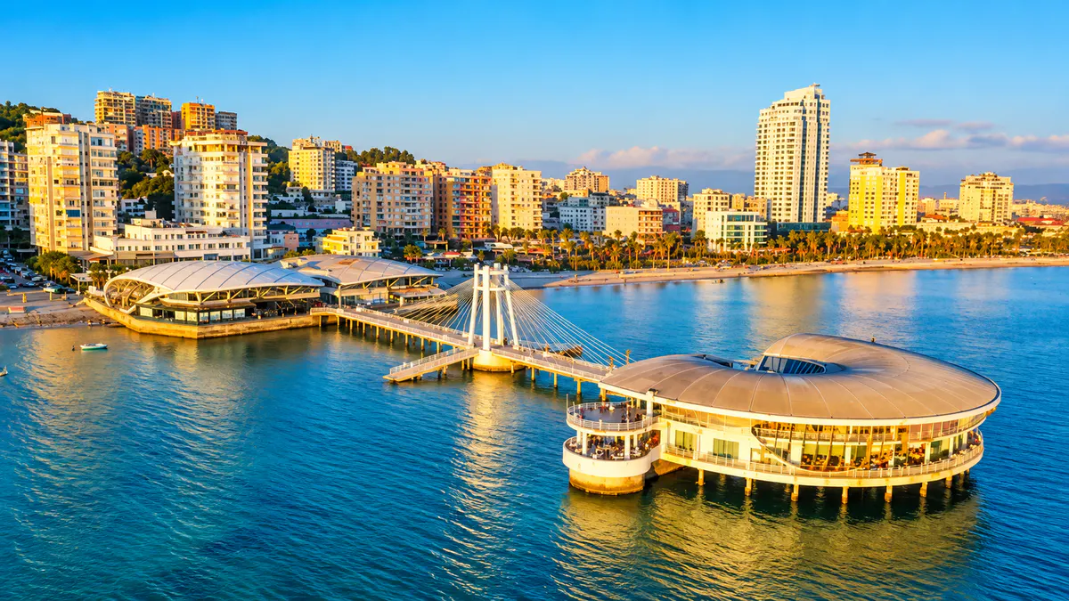 Pamje ajrore e bregdetit të Durrësit, Shqipëri, me restorante buzë detit, një mol për këmbësorët dhe Detin Adriatik.