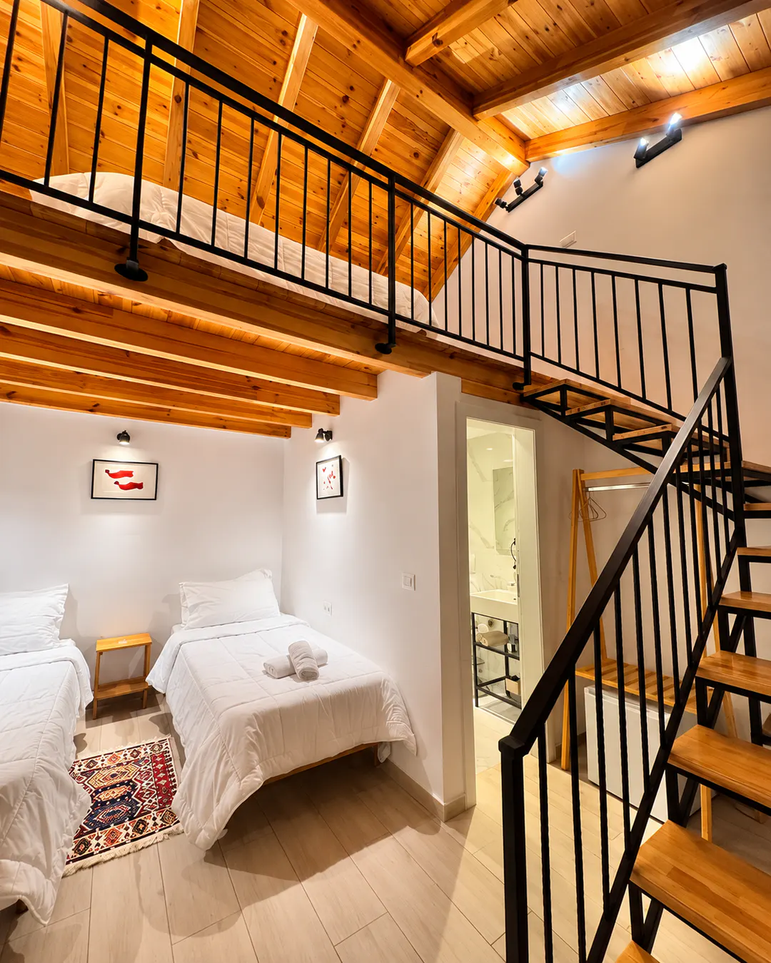 Accogliente camera familiare su due livelli con letti singoli, soffitto in legno e zona notte soppalcata al Gogo Moustache Guest House di Përmet, Albania