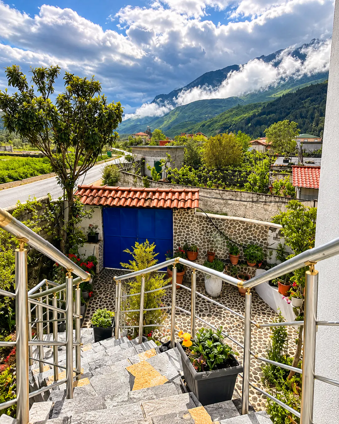 Suggestiva vista sulle montagne dal Guest House KrisHen, con cortile tradizionale in pietra, giardino e paesaggio verde a Përmet, Albania