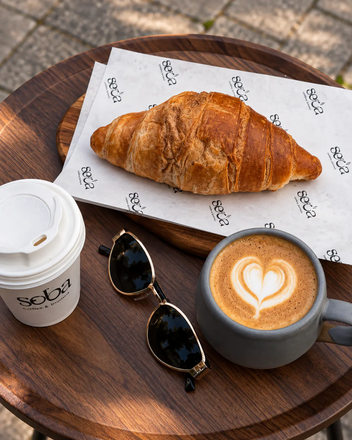 Freshly baked croissant and cappuccino with heart-shaped latte art at SECA COFFEE in Tirana's Blloku neighborhood.