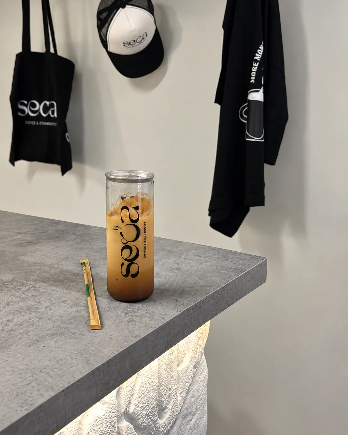 Iced latte served at SECA COFFEE in Blloku, Tirana, featuring minimalist interiors and branded coffee merchandise.