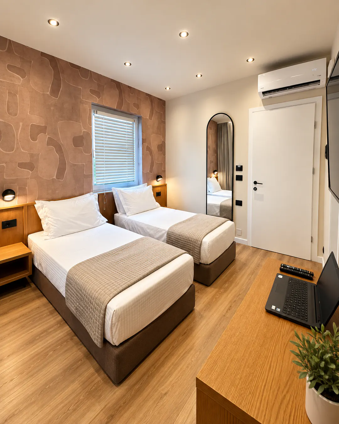 Moderna camera con due letti singoli al Serenity Rooms di Përmet, con pavimento in legno, aria condizionata e scrivania