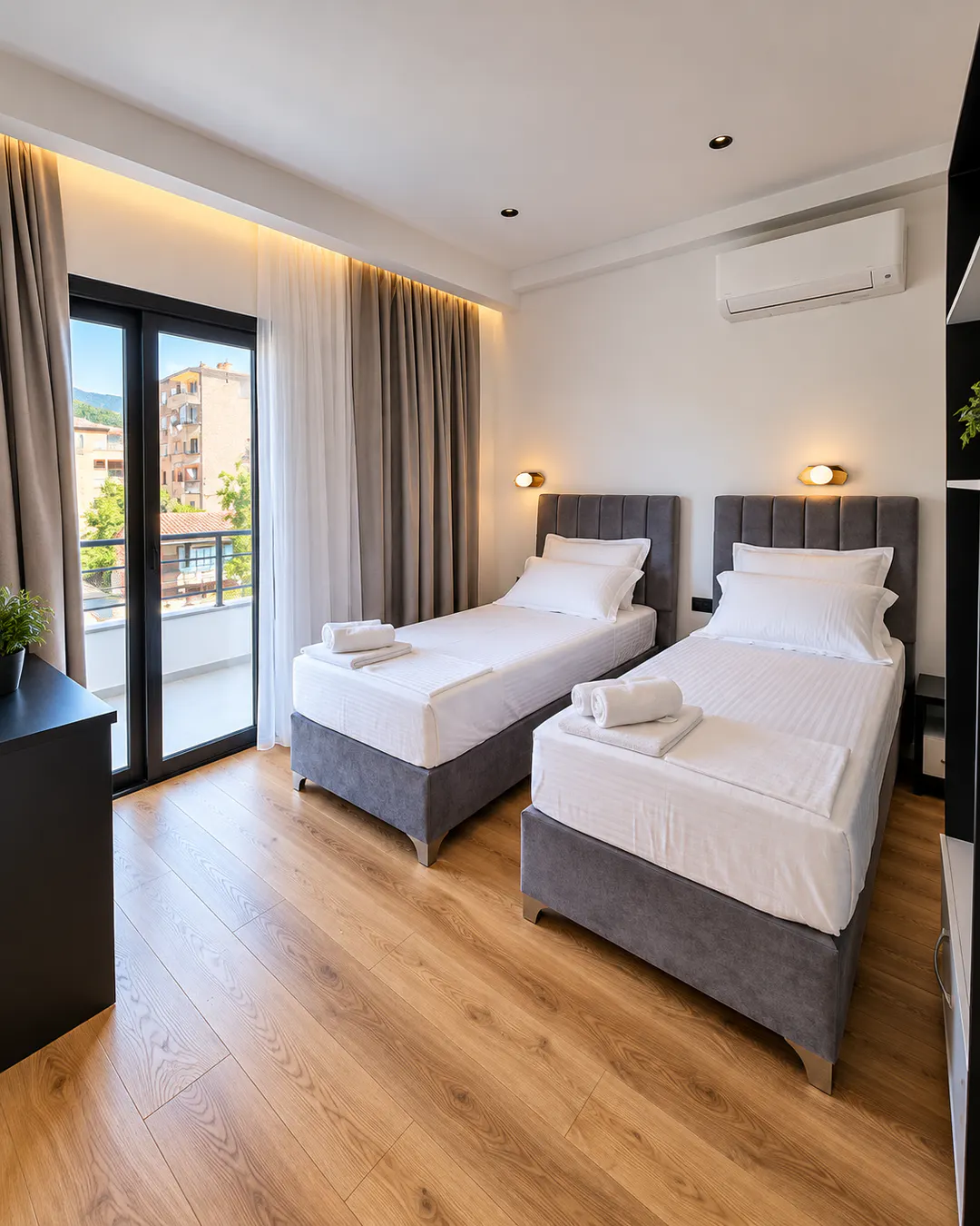 Luminosa camera con due letti singoli al White Villa, con arredamento moderno, aria condizionata e balcone privato
