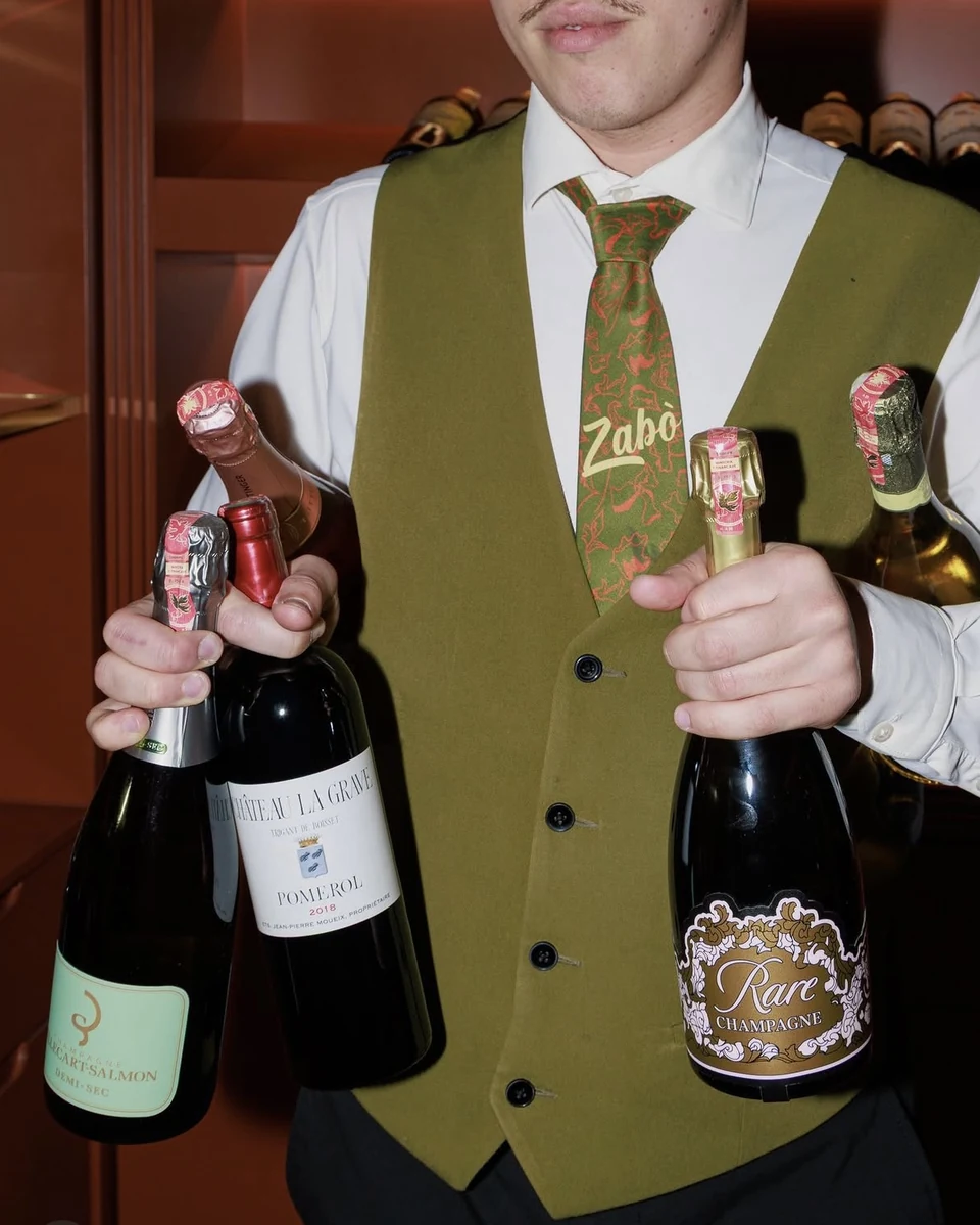 Server with wine and champagne bottles at ZABÒ Garden restaurant in Tirana.